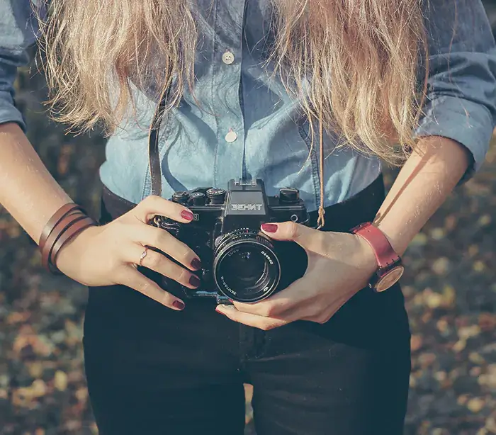 Woman holding a vintage camera.