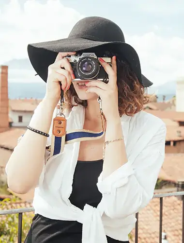 Woman holding camera in hat