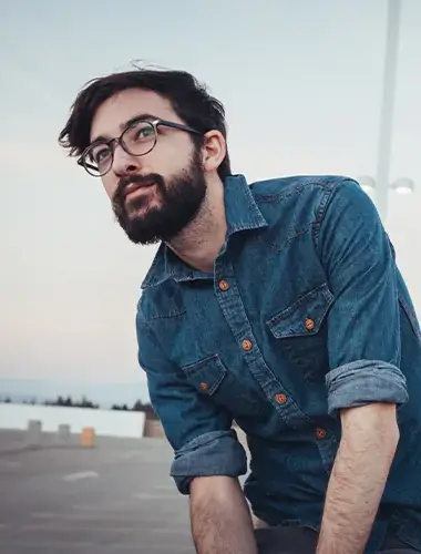 Man in denim shirt outdoors.
